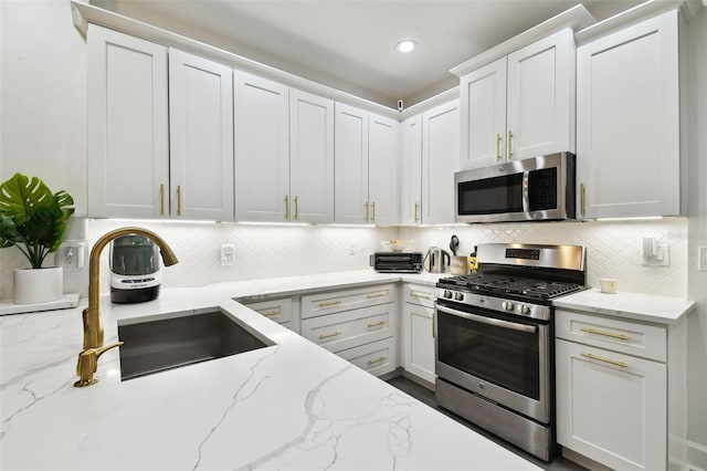 10011 Parley Dr, Tampa, FL 33626 - kitchen featuring a sink, backsplash, white cabinets, and stainless steel appliances