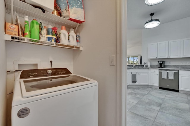 clothes washing area featuring washer / dryer, laundry area, and a sink