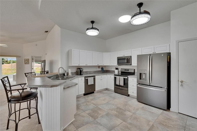 kitchen featuring appliances with stainless steel finishes, a sink, high vaulted ceiling, a peninsula, and white cabinetry