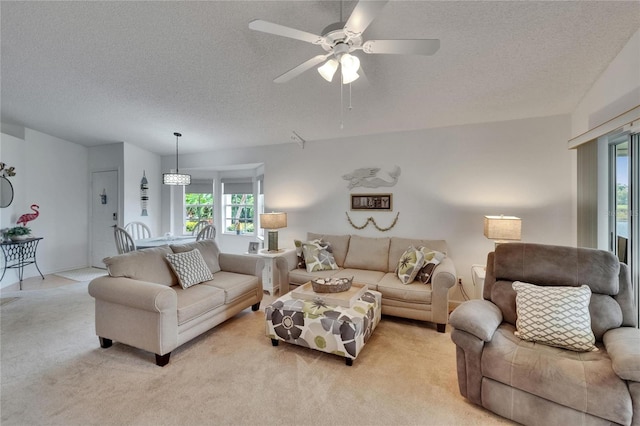 living room with light colored carpet, a textured ceiling, and ceiling fan