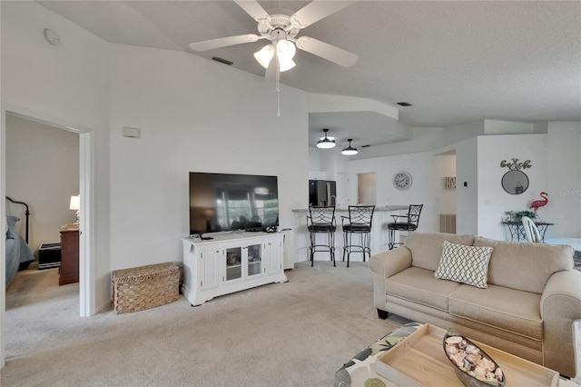 living room with ceiling fan, light carpet, visible vents, and lofted ceiling