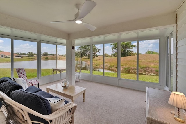 sunroom featuring a water view and ceiling fan