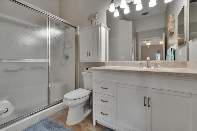 full bathroom featuring vanity, toilet, tile patterned floors, a ceiling fan, and a stall shower