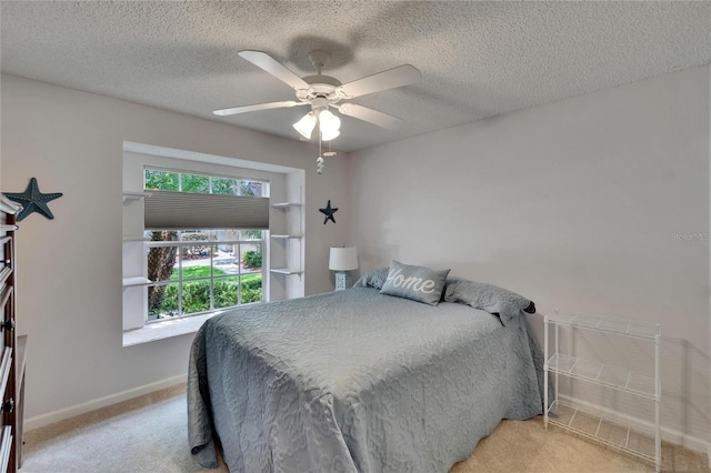 bedroom featuring baseboards, a ceiling fan, carpet flooring, and a textured ceiling