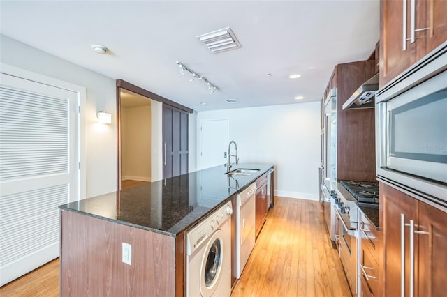 1120 E Kennedy Blvd Unit 615, Tampa, FL 33602 - kitchen with dark stone countertops, a kitchen island with sink, a sink, washer / dryer, and extractor fan