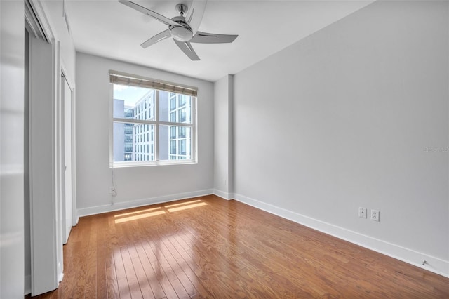 1120 E Kennedy Blvd Unit 615, Tampa, FL 33602 - unfurnished bedroom featuring a closet, baseboards, a ceiling fan, and wood finished floors