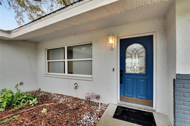 entrance to property featuring stucco siding