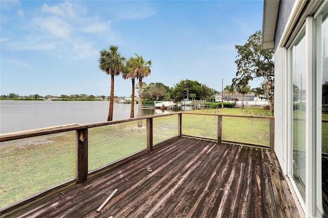 wooden terrace featuring a water view and a yard