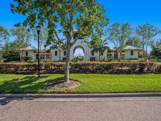 single story home featuring stucco siding, a front lawn, and metal roof