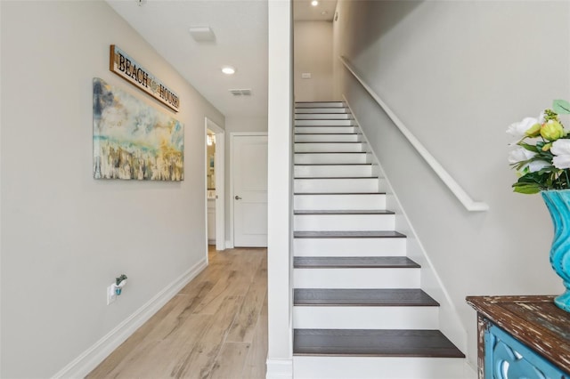 stairway with visible vents, baseboards, recessed lighting, and wood finished floors
