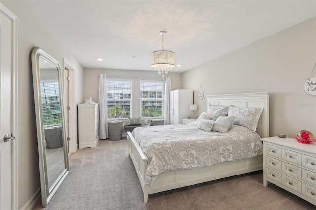 bedroom with a chandelier and light carpet