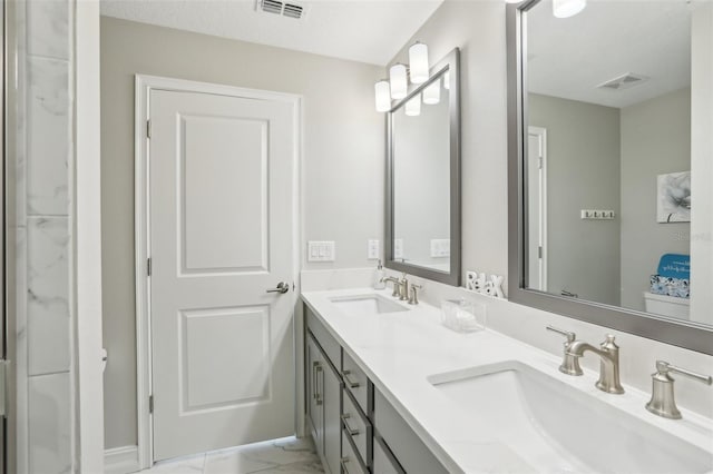 full bathroom featuring marble finish floor, a sink, and visible vents