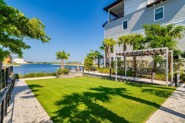 view of home's community with a water view, a lawn, and a pergola