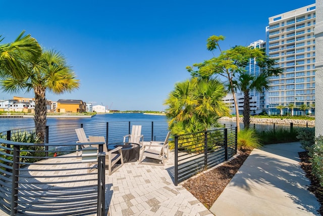exterior space with an outdoor fire pit, a patio area, and a water view