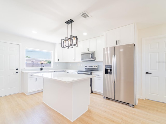 kitchen featuring light countertops, light wood-style flooring, visible vents, and appliances with stainless steel finishes
