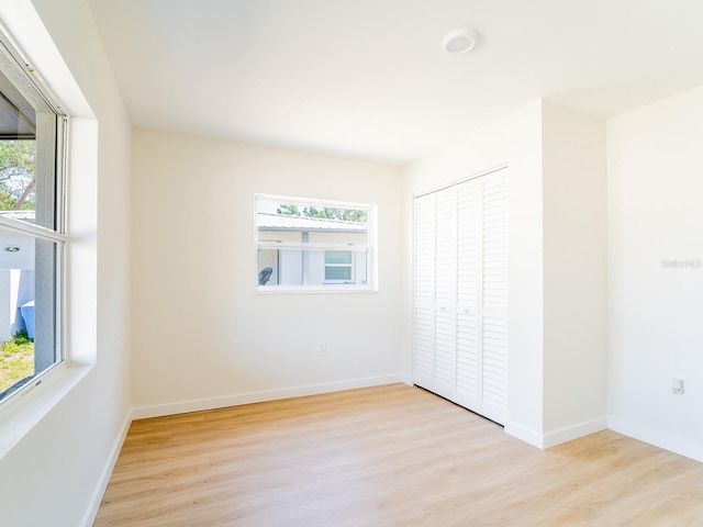 unfurnished bedroom featuring a closet, baseboards, and wood finished floors