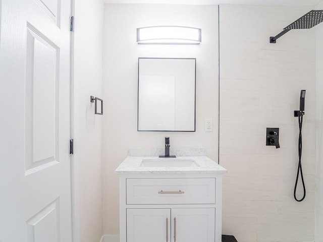 full bath with tiled shower and vanity