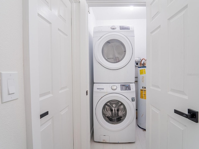 laundry area featuring stacked washing maching and dryer, laundry area, and water heater