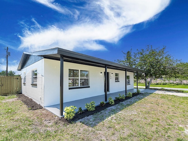 view of property exterior with fence and a lawn