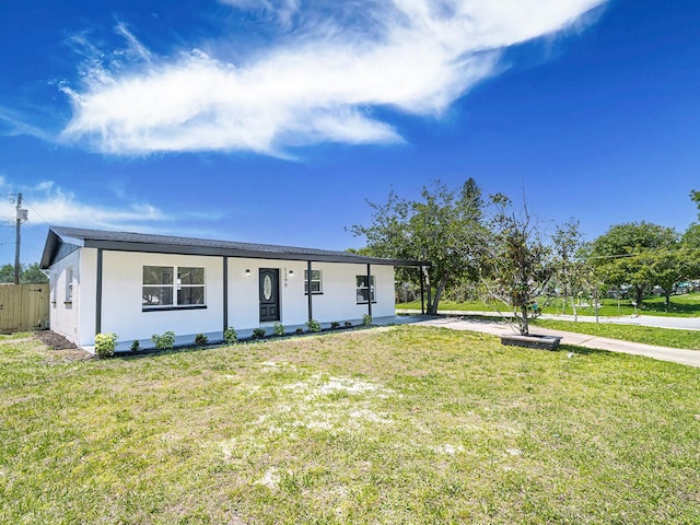 view of front of house featuring a front yard, concrete driveway, fence, stucco siding, and an attached carport