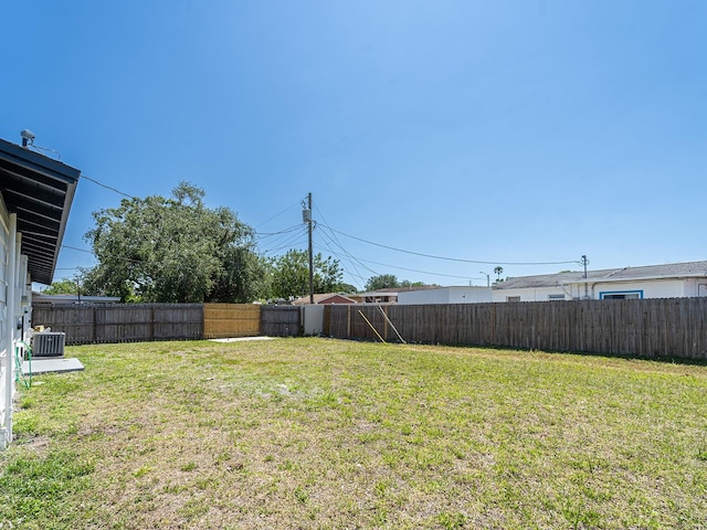 view of yard with central AC unit and a fenced backyard