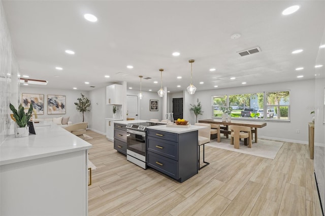 1905 Oro Ct, Clearwater, FL 33764 - kitchen featuring light wood-style floors, visible vents, white cabinetry, and stainless steel range with electric cooktop
