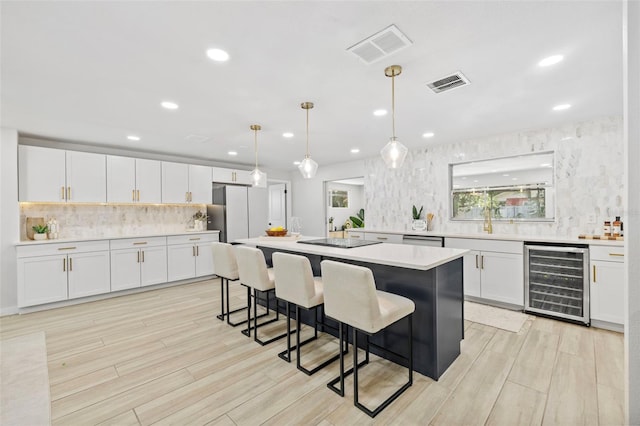1905 Oro Ct, Clearwater, FL 33764 - kitchen featuring a kitchen bar, wine cooler, freestanding refrigerator, and visible vents
