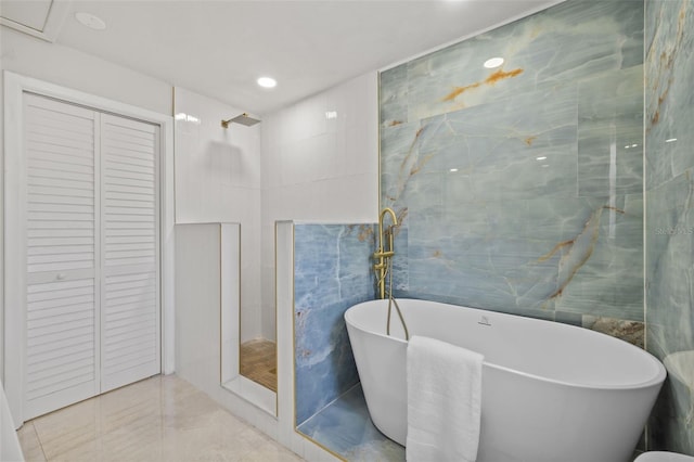 1905 Oro Ct, Clearwater, FL 33764 - full bathroom featuring a closet, a freestanding bath, tile walls, and a tile shower