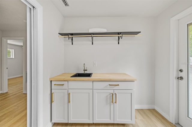 1905 Oro Ct, Clearwater, FL 33764 - bar featuring light wood-style flooring, baseboards, a sink, and visible vents