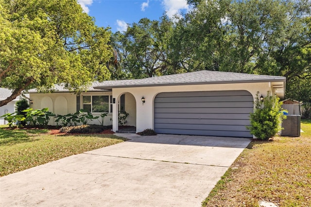1905 Oro Ct, Clearwater, FL 33764 - ranch-style home with concrete driveway, stucco siding, a garage, and a front lawn