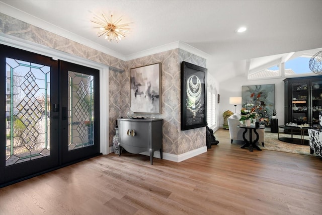 entrance foyer featuring french doors, a healthy amount of sunlight, wood finished floors, and vaulted ceiling