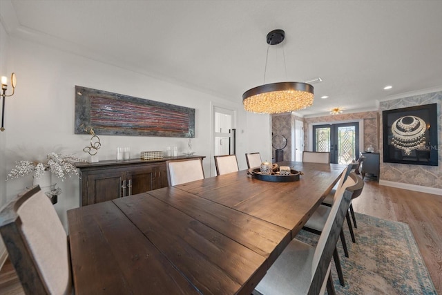 dining area with baseboards, crown molding, recessed lighting, wood finished floors, and french doors