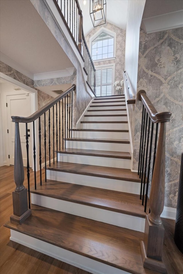 stairway featuring vaulted ceiling and wood finished floors