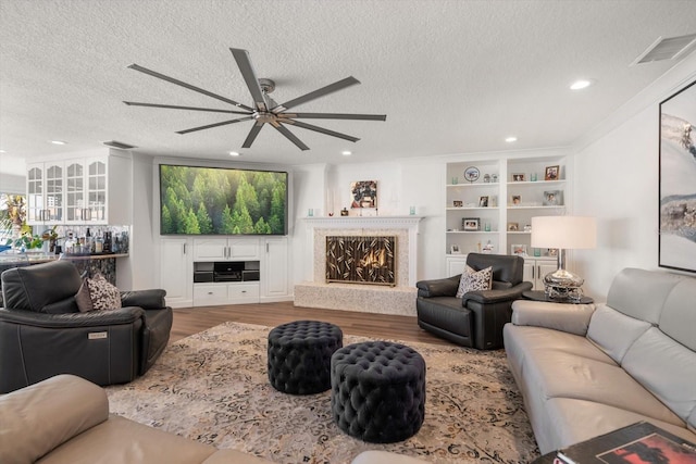 living area featuring recessed lighting, a textured ceiling, visible vents, ceiling fan, and wood finished floors