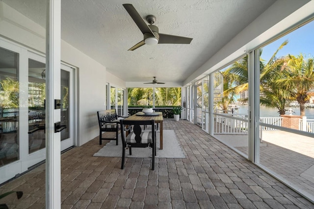 sunroom / solarium with ceiling fan and outdoor dining space