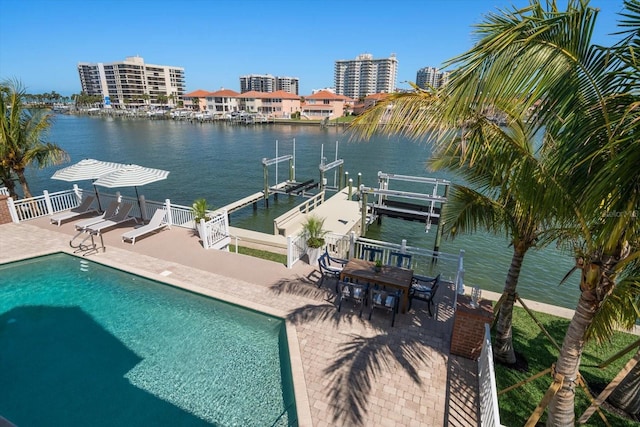exterior space featuring a water view, a patio, an outdoor pool, and boat lift
