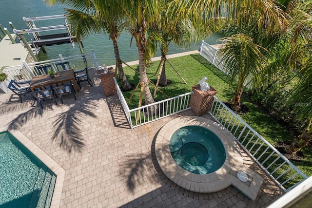 view of pool with a yard, a water view, a patio, an in ground hot tub, and outdoor dining area