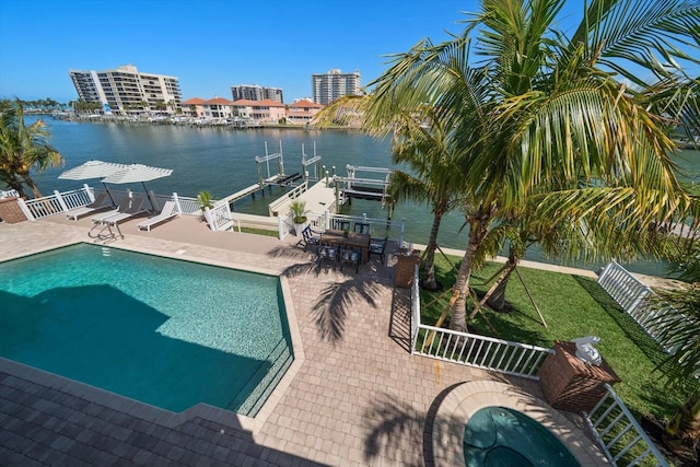 pool featuring boat lift, a dock, a patio area, a water view, and fence