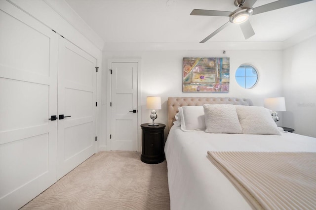 bedroom featuring a closet, light colored carpet, and ceiling fan