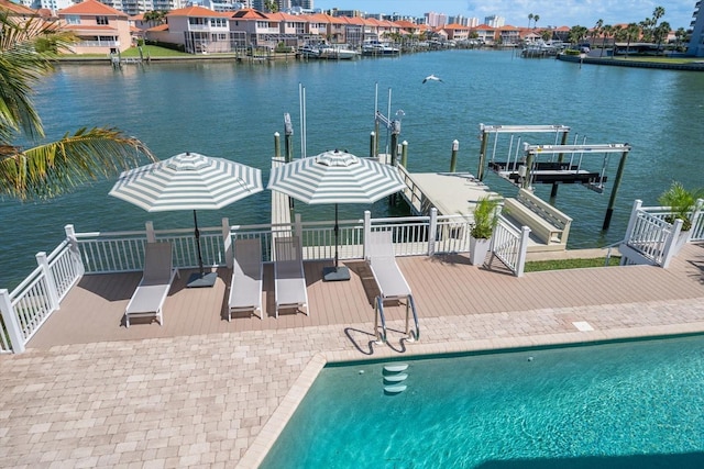 view of swimming pool featuring a water view, a boat dock, and boat lift