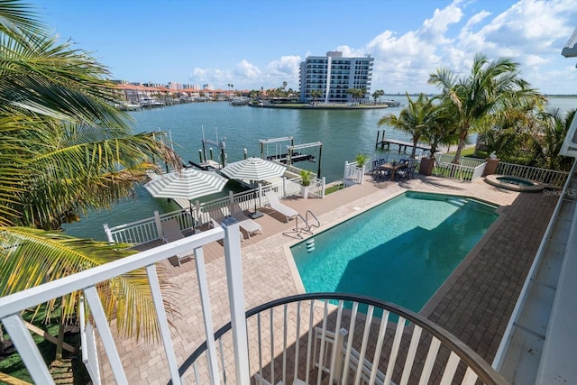 view of pool with a patio area, a water view, fence, an in ground hot tub, and a fenced in pool