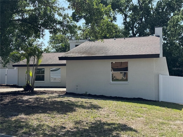 3924 Orchard Hill Cir, Palm Harbor, FL 34684 - back of property with a yard, roof with shingles, stucco siding, and fence