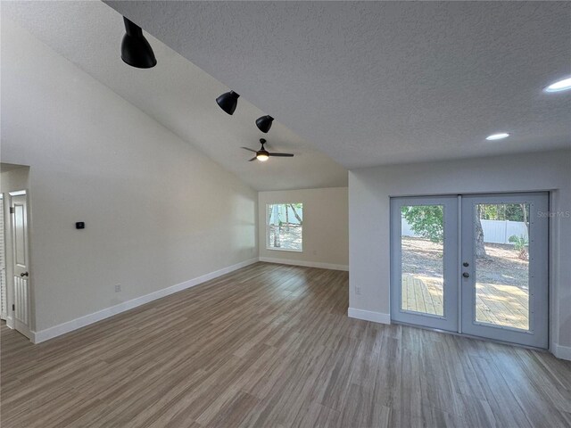 3924 Orchard Hill Cir, Palm Harbor, FL 34684 - unfurnished living room with french doors, baseboards, a textured ceiling, and wood finished floors