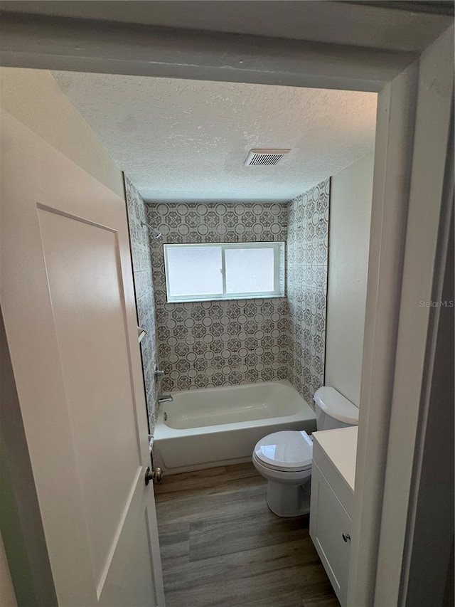 3924 Orchard Hill Cir, Palm Harbor, FL 34684 - bathroom featuring visible vents, toilet, a textured ceiling, wood finished floors, and shower / tub combination