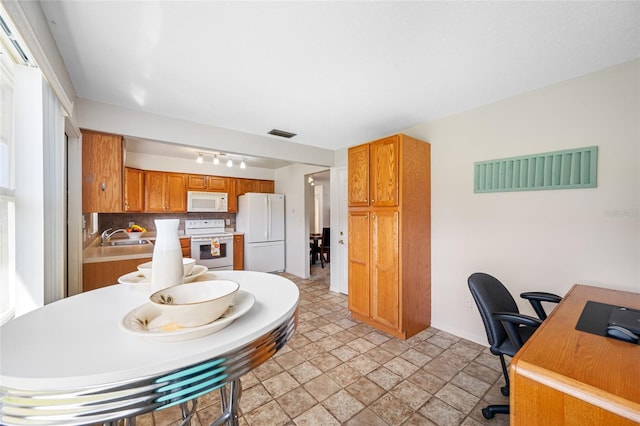 6920 Lafayette N Unit 6920, Pinellas Park, FL 33781 - kitchen featuring rail lighting, white appliances, backsplash, visible vents, and a sink