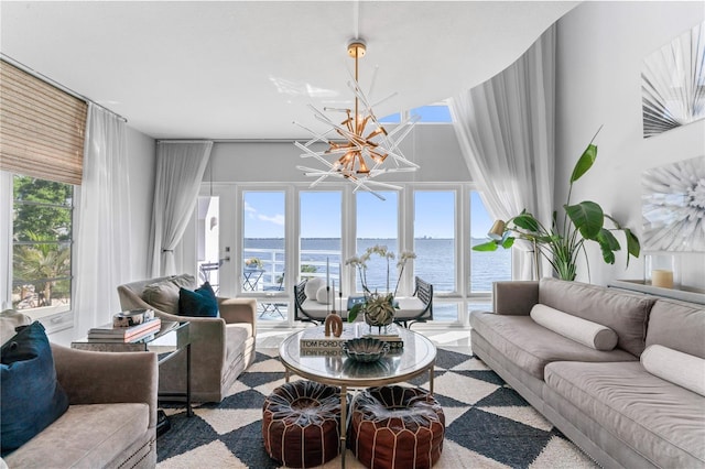 living room featuring a chandelier and a water view