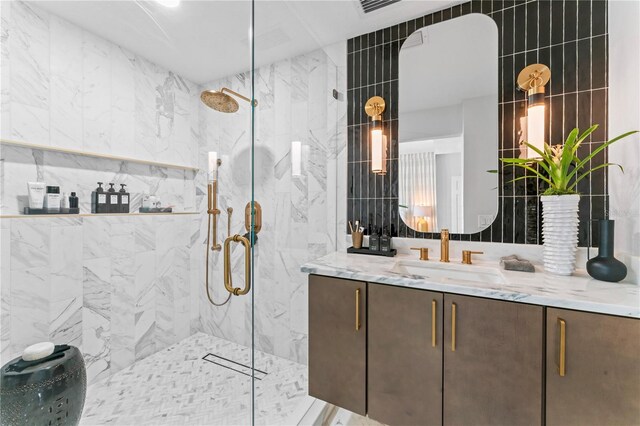 full bathroom with vanity, tile walls, and a marble finish shower