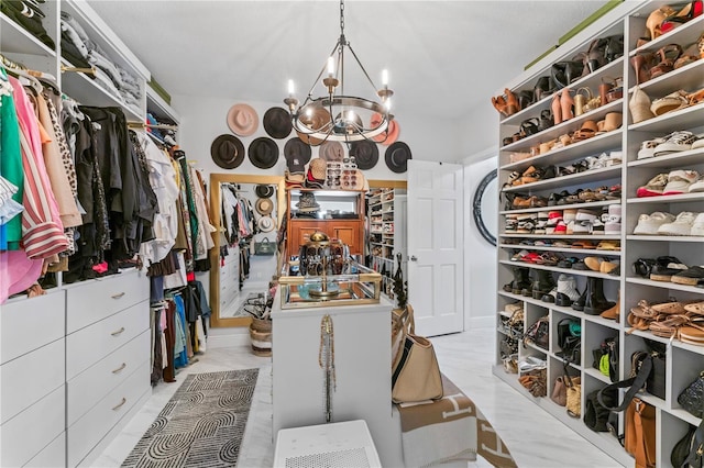 walk in closet with an inviting chandelier