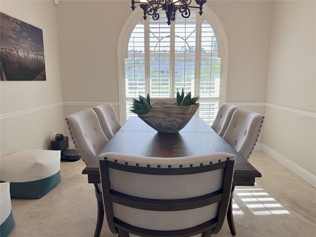 dining area with plenty of natural light, baseboards, an inviting chandelier, and tile patterned flooring