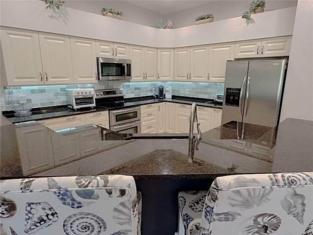 kitchen featuring tasteful backsplash, white cabinetry, and stainless steel appliances